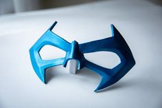 a blue mask is sitting on a white surface