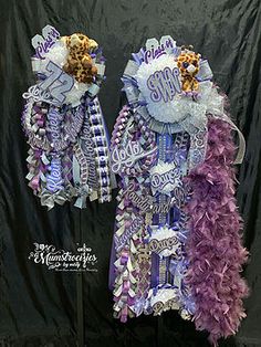 two purple and white decorations on display in front of a black backdrop with the words congratulations