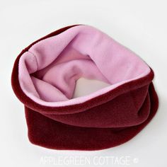 a pink and red scarf laying on top of a white surface