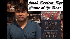 a man standing in front of a book shelf with the name of the rose on it