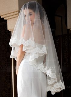 a woman wearing a wedding veil and dress