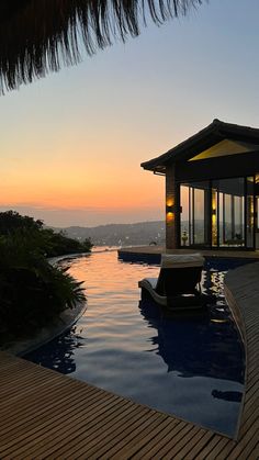 the sun is setting over an outdoor swimming pool