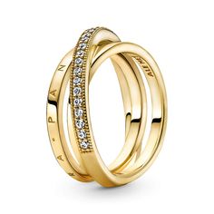 Go for linear layers with the Crossover Pavé Triple Band Ring. Hand-finished in 14K gold-plated metal, this ring features three bands, with one diagonally overlapping the other two. One inner band is embossed with the Pandora logo, the other inner band is polished and the outer band features clear cubic zirconia pavé framed by micro-beading. Inspired by the mesmerising structure of the solar system, this ring brings sleek, structural sophistication to any look. Silver Wedding Gifts, Pandora Logo, Triple Band Ring, Pandora Rings, Rings Jewelry Fashion, Pave Ring, Thomas Sabo, Mua Sắm, Gold Plated Rings