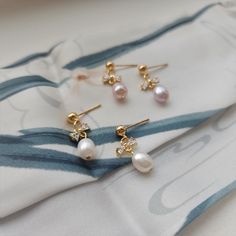 Our cute mini bow pearl earrings are made with natural freshwater pearls, zircon bow knot and 14k gold-plated studs which are good for delicate ears. Size: approx. 0.25" wide and 0.825" long Delicate Pearl Earrings With Cubic Zirconia For Gift, Delicate Cubic Zirconia Pearl Earrings For Gift, Pearl Embellished Cubic Zirconia Earrings As Gift, Dainty Gold Pearl Earrings With Cubic Zirconia, Pearl Charm Cubic Zirconia Earrings For Gift, Pearl Charm Earrings With Cubic Zirconia As Gift, Gift Pearl Earrings With Cubic Zirconia, Gift Cubic Zirconia Pearl Pendant Earrings, Stud Pearl Earrings