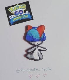 an image of a pixel art pin with the word pokemon on it's back