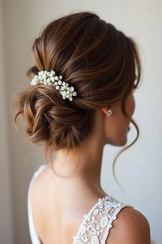 a woman wearing a hair comb with flowers in it's back and her hair pulled up into a low bun