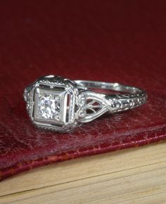 a close up of a ring on top of a book with a red leather cover