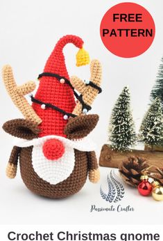 a crochet christmas gnome is sitting next to a pine tree with cones on it