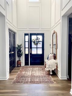 an entryway with white walls and wood floors