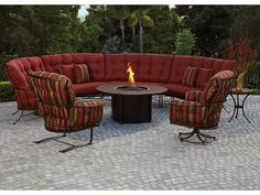 an outdoor fire pit surrounded by chairs and tables