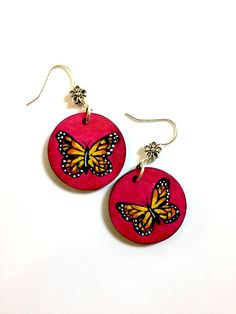 two pink earrings with yellow butterflies on them