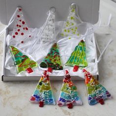 four glass christmas trees are in a box