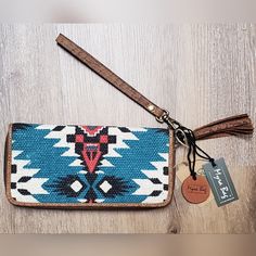 Amazing Color Combinations Make This Wallet Truly Eye-Catching. The Upcycled Woven Rug Features Hues Of Red, Turquoise, Ivory And Charcoal. Special Accents In Warm Chocolate Leather Outline The Edges And Tassel. Removal Wristlet Strap For Another Option To Carry. Interior Features Spacious Sections, Including A Zippered Pocket. Wrap-Around Zipper Closure Keeps Everything Snug And Secure. A Beautiful, Eye-Catching Design! Brand New With Tags! Trendy Blue Wristlet For Everyday Use, Blue Trendy Wristlet, Trendy Blue Wristlet, Adjustable Clutch Wallets For Travel, Blue Bohemian Clutch For Everyday Use, Handmade Clutch Wristlet For Everyday Use, Bohemian Pouch Wallet For Everyday Use, Handmade Trendy Wristlet For Everyday Use, Trendy Handmade Wristlet For Everyday