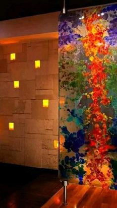 an art piece is displayed in front of a brick wall with candles lit up on it