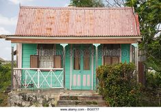 a small green house sitting on top of a lush green hillside