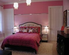 a bedroom decorated in pink and white with a bed, nightstands, lamps and dresser