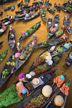 many small boats filled with people and vegetables