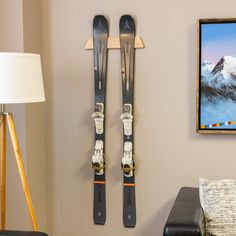 two skis are hanging on the wall next to a chair and lamp in a living room