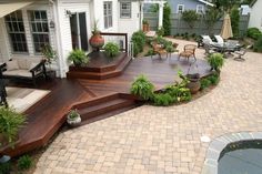 a deck with steps leading up to the patio and seating area in front of it