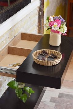 a basket with sunglasses sitting on top of a table next to a flower pot and stairs