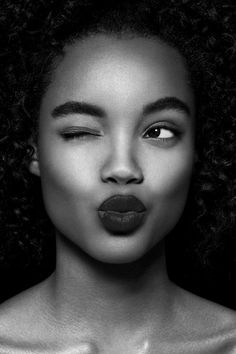 a black and white photo of a woman's face with dark lipstick on her lips