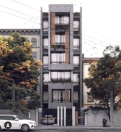 a white car parked in front of a tall building with balconies on the windows