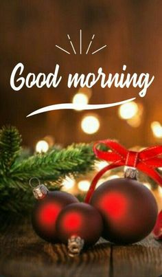 two christmas ornaments sitting on top of a wooden table next to a pine tree with the words good morning