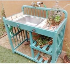 an outdoor sink with plants growing on the top and bottom shelf in front of it