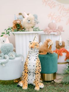 an animal themed birthday party with stuffed animals and cake toppers on the table in front of them