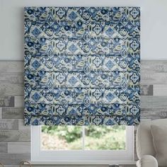 a blue and white patterned roman blind in front of a window