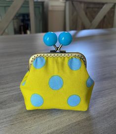 a yellow and blue purse sitting on top of a wooden table covered in polka dots