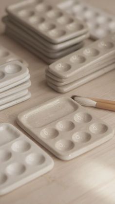 a table topped with lots of white plastic trays filled with different sized and shapes