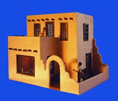 a toy house made out of cardboard with a man on the front door and windows