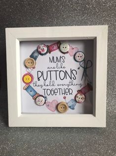 a white frame with buttons in it that says mums are little buttons they're something together