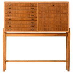 a wooden dresser with many drawers on it's top and bottom shelf, against a white background