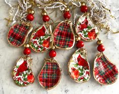 six red and green christmas ornaments on a marble surface with gold trim around the edges