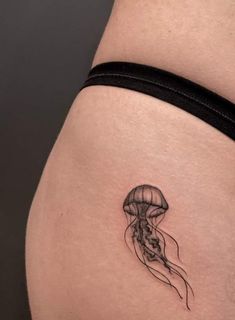 a woman's thigh with a small tattoo of a jellyfish on the side