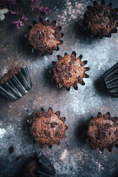 several chocolate muffins sitting next to each other on top of a gray surface