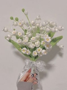 a hand holding a bouquet of white flowers