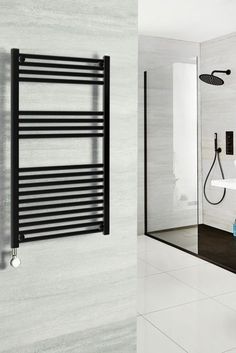 an image of a bathroom setting with white tile and black towel racks on the wall