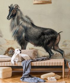 a goat standing on top of a bed in front of a wall with a painting