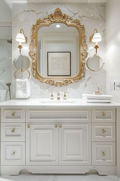 a white bathroom with gold accents and marble counter tops