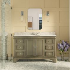 a bathroom with a sink, mirror and flowers in the vase on the counter top