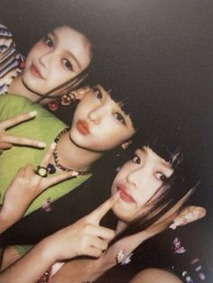 three young women posing for the camera with their fingers on their lips and one pointing at something