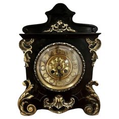 an ornate black and gold clock on a white background