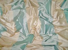 an image of a blue and beige striped material that looks like silk or satin fabric