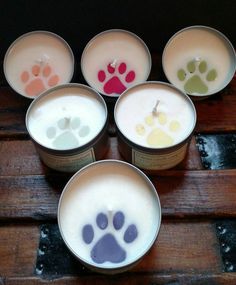 six cups with different colored paw prints on them sitting on a wooden table next to each other