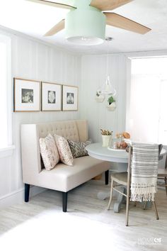 a living room with a couch, table and pictures on the wall in it's corner