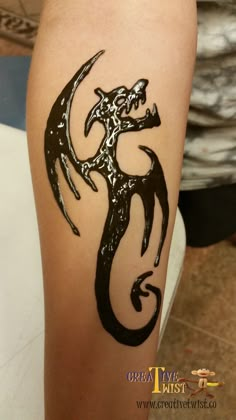 a black and white tattoo on the leg of a woman's arm with a dragon