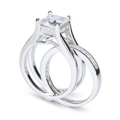 Glistening and glamorous, this ring set will win her heart. It features a princess cut center stone on polished shank while additional princess cut stones adorn the inner band. An awesome look of love, this interchangeable style ring set is certain to leave her spellbound. Carat Weight: 2.85 ctStone Size: 7*7 mmStone Type: Jeulia® StoneNumber of Stones: 1 Stone Color: Diamond WhiteStone Shape: PrincessCarat Weight: 0.94 ctStone Size: 1.5*1.5,1.2 mmStone Type: Jeulia® StoneNumber of Stones: 31 Stone Color: Diamond WhiteStone Shape: Princess, RoundWeight: 10.1 gWidth: 8.4 mmHeight: 8.33 mmThickness: 6 mmMaterial: 925 SilverPlating Color: Silver Princess Cut Wedding Ring Set, Princess Cut Ring Set, Dream Wedding Ring, Wedding Rings Princess Cut, Sterling Silver Rings Set, Princess Cut Rings, Silver Ring Set, Large Jewelry, Wedding Ring Set